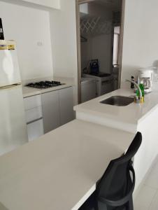 eine weiße Küche mit einer Spüle und einem Herd in der Unterkunft Espectacular apartamento en Condominio Peñazul con BBQ in Ricaurte