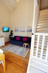een woonkamer met een blauwe bank en een trap bij נענע in Keshet