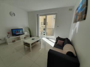 - un salon avec un canapé et une table dans l'établissement Sliema Ferries Apartment, à Sliema