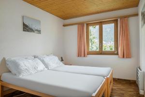 a bedroom with two beds and a window at Trimka in Fiesch