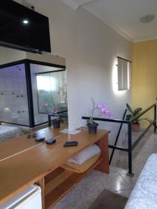 een woonkamer met een tafel en een groot raam bij Miragem Chalés in Serra Negra