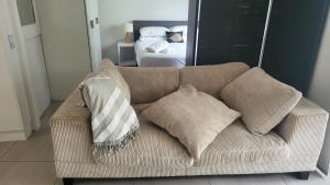 a couch with pillows on it in a bedroom at Mooloolaba Beach Beachwalk in Mooloolaba