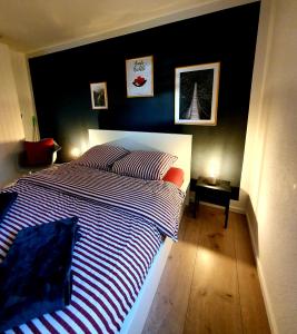 ein Schlafzimmer mit einem großen Bett und einer schwarzen Wand in der Unterkunft Ferienwohnung Am Musbach in Badenweiler-Sehringen in Badenweiler