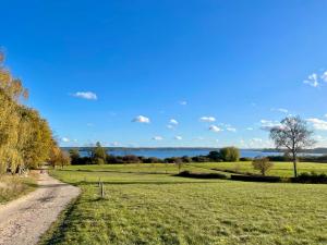 a dirt road next to a field with water in the background at Ferienhaus Rupnow Plau am See in Plau am See