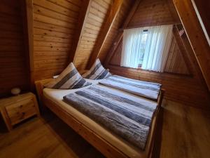 a bed in a wooden room with a window at Haus Blume in Carolinensiel