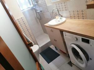 a bathroom with a washing machine and a sink at Delightful - Színes és pihentető in Odorheiu Secuiesc