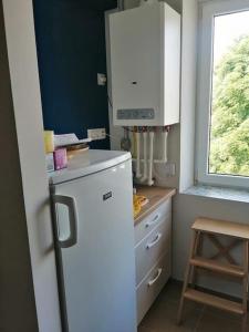 a kitchen with a white refrigerator and a window at Delightful - Színes és pihentető in Odorheiu Secuiesc