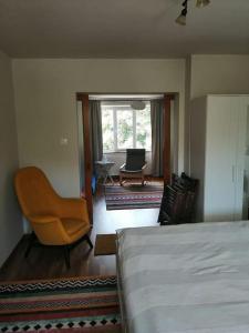 a bedroom with a bed and a chair and a living room at Delightful - Színes és pihentető in Odorheiu Secuiesc