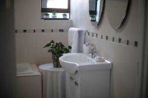 ein weißes Badezimmer mit einem Waschbecken und einem Spiegel in der Unterkunft Three Stones Executive Apartments in Maseru