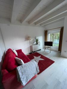 a living room with a red couch and a red rug at Villa Natura appartamento Open Space con giardino in Trento +22 photos
