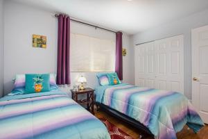 two beds in a room with purple curtains at Alpine Escape in Leavenworth
