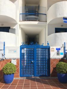 niebieskie drzwi przed budynkiem w obiekcie 2 Paradise of Benalmádena Residencial Los Patos II a 300 metros de la playa y supermercados, wifi gratis, vistas a la montaña w mieście Benalmádena