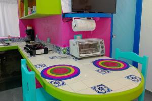 a toy kitchen with a table with a microwave at Beautiful & Cozy Studio in Akumal Paradise-Wifi, AC in Akumal