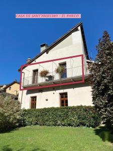 a white building with two windows and a balcony at Casa di Sant'Anselmo - Il Parco - CIR VDA AOSTA 0191 in Aosta