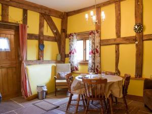ein Esszimmer mit gelben Wänden sowie einem Tisch und Stühlen in der Unterkunft The Granary in Kingsland