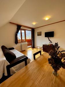 een woonkamer met een tafel en een bank bij Ana Antloga Apartments in Bled