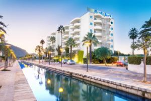 a view of a hotel with palm trees and a canal at Alcudia Beach Apartments in Port d'Alcudia