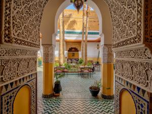 een toegang tot de lobby van een resort met tafels en stoelen bij Palais Tinmel Marrakech in Marrakesh