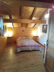 - une chambre avec un lit dans une pièce dotée de plafonds en bois dans l'établissement Chalet Indépendant " L'anfian-ne", aux Contamines-Montjoie