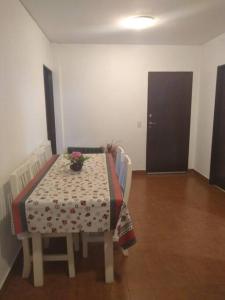 a table and chairs with a table and flowers on it at Depto para 4 Pinamar centro NO Grupos jóvenes in Pinamar