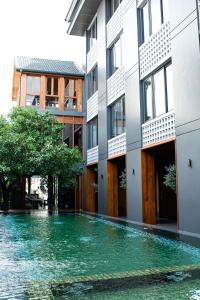 - un bâtiment avec une piscine d'eau en face dans l'établissement Hotel Loy Chiang Mai, à Chiang Mai