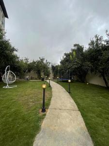 a walkway in a park with a ball in the grass at فيلا اورنيلا in Al Hada