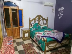 a bedroom with a bed with a green comforter at Labib Guest House in Aswan
