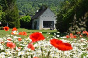 a field of red and white flowers in front of a building at Gîte dans Parc de Sculptures - Gîte "Zanzibar" in Port-Mort