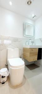 Baño blanco con aseo y lavamanos en 901 Loft con jacuzzi privado cerca al barrio Laureles, en Medellín