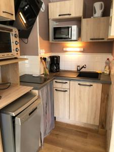 a small kitchen with a sink and a microwave at Appartement 3è étage à St-Marie-de-Campan in Sainte-Marie-de-Campan