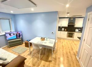 uma sala de estar com uma mesa branca e uma cozinha em Modern Spacious Annex -Ground Floor em Brightlingsea