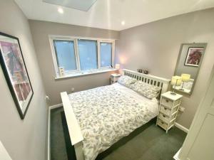 um pequeno quarto com uma cama e 2 janelas em Modern Spacious Annex -Ground Floor em Brightlingsea