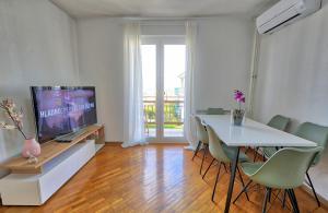a living room with a television and a table with chairs at Bellevue in Izola