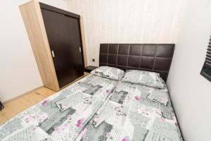 a bedroom with a bed with a bedspread on it at ECO Hоuses - Camping Gradina in Chernomorets