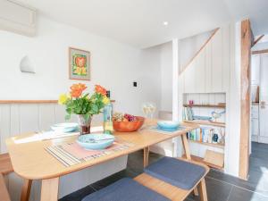 stół jadalny z miskami i kwiatami w obiekcie Welcome Cottage w mieście Woolfardisworthy
