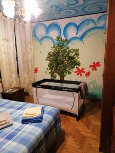 1 dormitorio con 1 cama con una planta en la pared en Colori nel parco en Cesiomaggiore