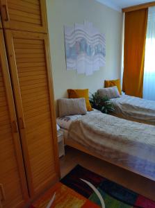 a bedroom with two beds and a window at Pihenő Zug Apartman in Budapest