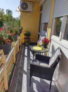 a patio with chairs and a table and some plants at Pihenő Zug Apartman in Budapest