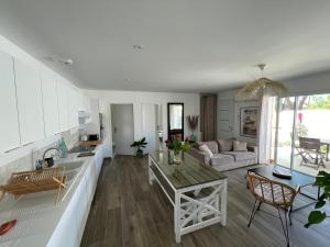 una cucina e un soggiorno con divano e tavolo di Maison 300m de l’océan, 4 a 6 personnes a Mimizan