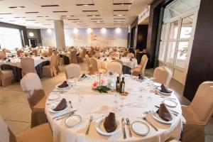 ロハにあるHotel Abades Lojaの白いテーブルと椅子が備わる宴会場