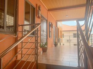 un pasillo de una casa con puerta y escaleras en Lurelin Village Apartments, en Accra