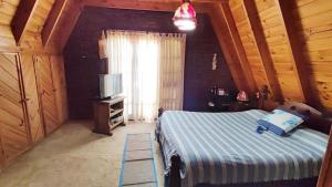 Schlafzimmer mit einem Bett, einem Fenster und einer Leiter in der Unterkunft Coca in Santa Clara del Mar