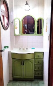 ein Badezimmer mit einem grünen Waschbecken und einem Spiegel in der Unterkunft Coca in Santa Clara del Mar