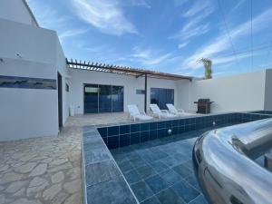 een villa met een zwembad en een huis bij Casa Y in Tolú