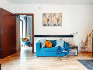 a living room with a blue couch and a chair at Przystanek Góry in Szczyrk