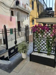 a wrought iron fence with flowers on a balcony at La Magnolia Rooms in Procida