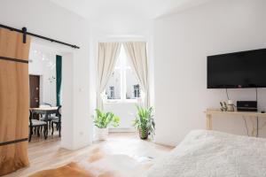 a white bedroom with a bed and a dining room at Old Town Apartment in Poznań