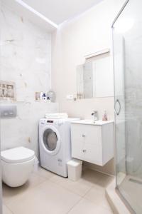 a white bathroom with a washing machine in it at Old Town Apartment in Poznań