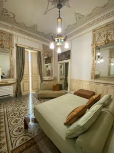 - une chambre avec un lit et un canapé dans l'établissement MEA DOMUS Mergellina, à Naples