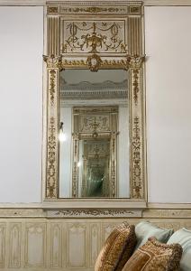 - un miroir mural avec un canapé en face dans l'établissement MEA DOMUS Mergellina, à Naples